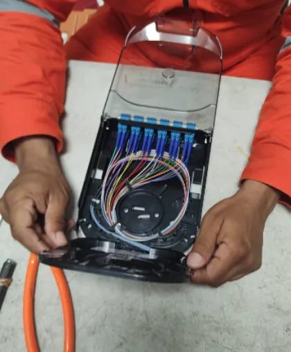 Person holding an open fiber optic splice tray.
