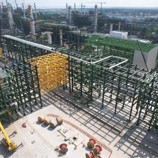 Large industrial construction site with steel framework and cranes.